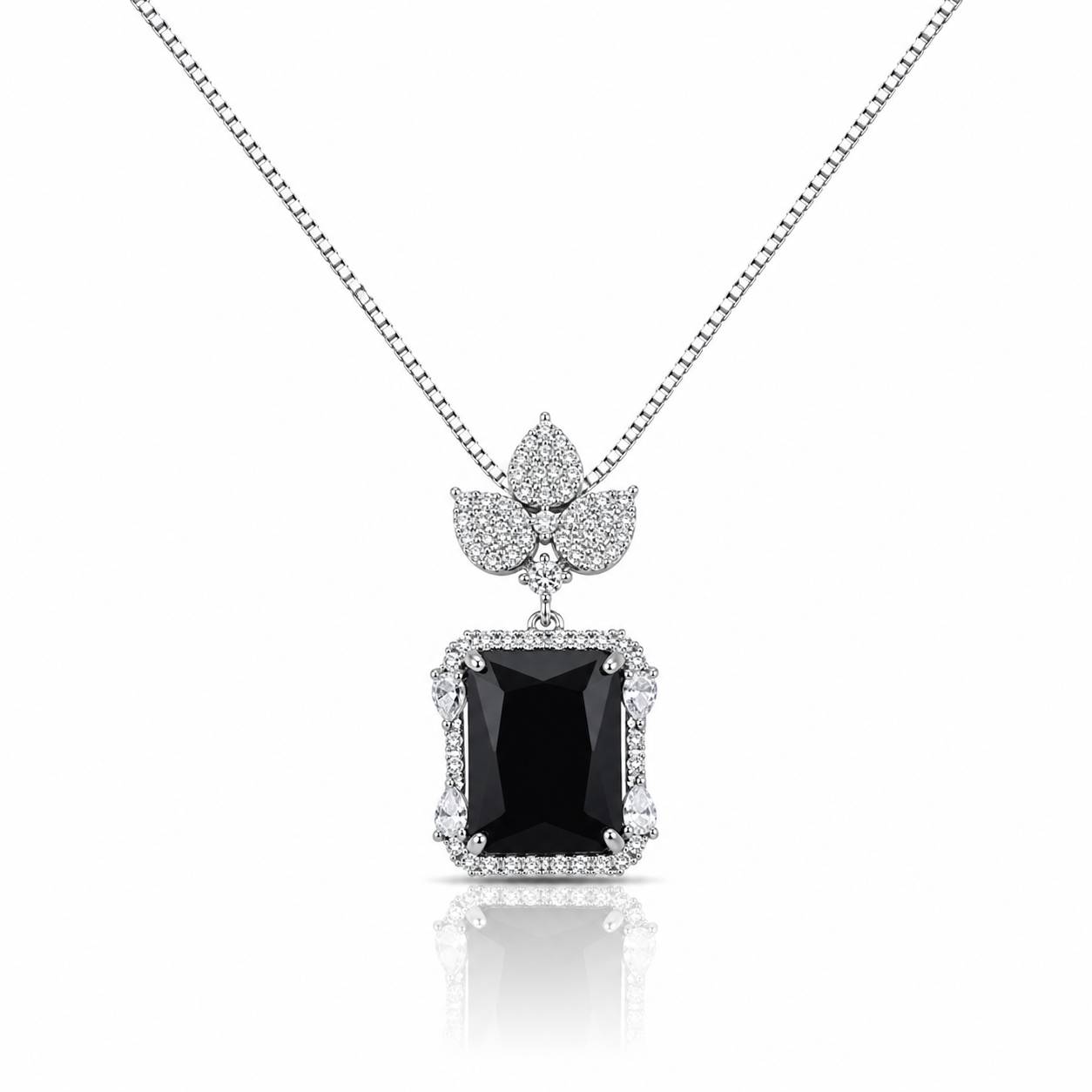 Silver pendant necklace featuring a large emerald-cut black crystal surrounded by sparkling zircon stones with a floral-inspired top design on a delicate box chain.